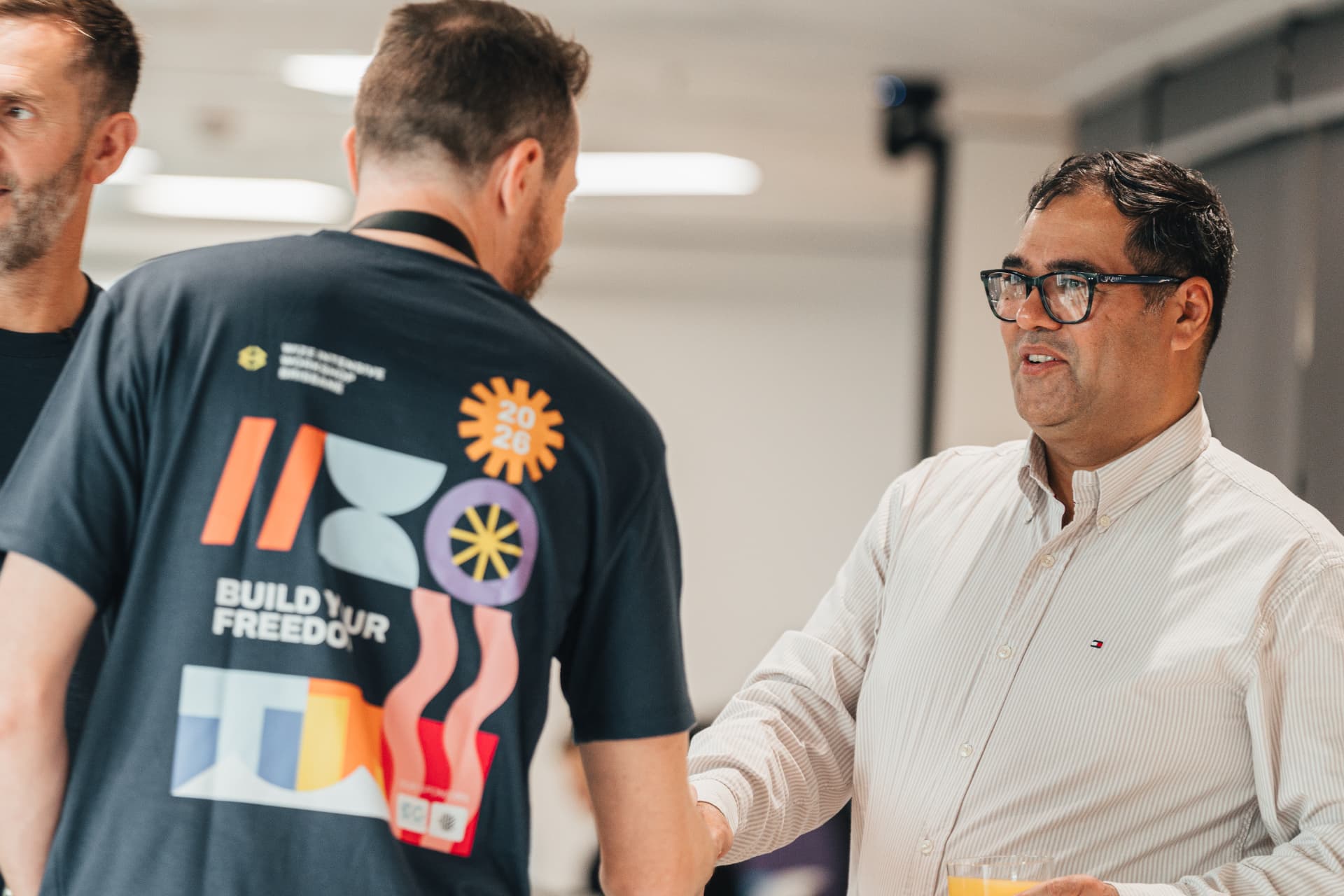 Two people shaking hands and talking at a Wize workshop